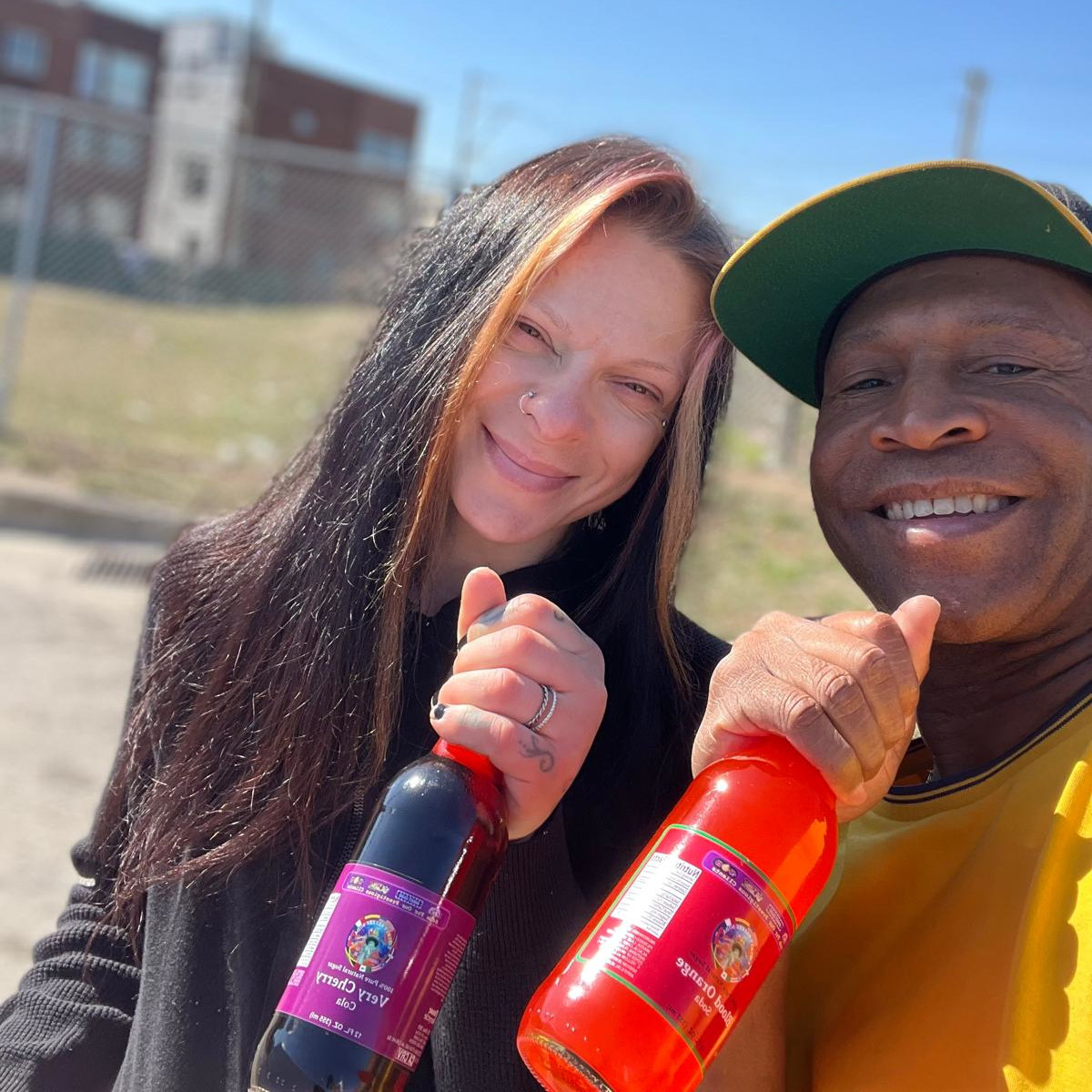 Person holding a Liberty Breeze soda against a colorful mural